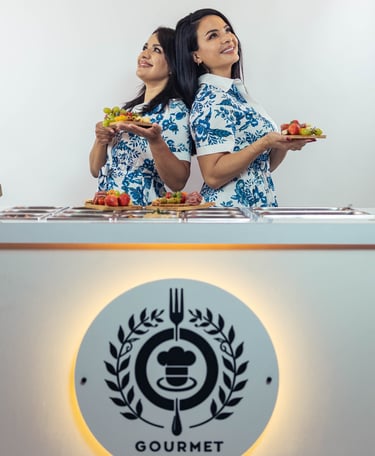 two women standing in front of a counter top
