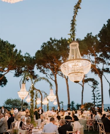 Elegant outdoor dinner at Villa El Rincon with chandeliers and guests under the trees