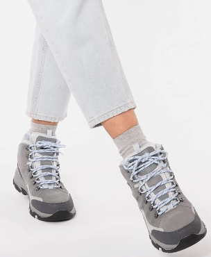 a woman's feet in grey shoes with laces