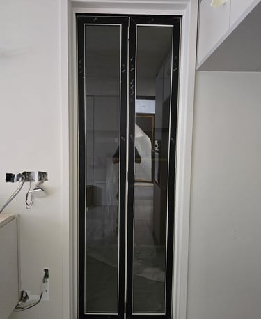 Modern black framed glass bifold doors installed in a residential interior renovation.