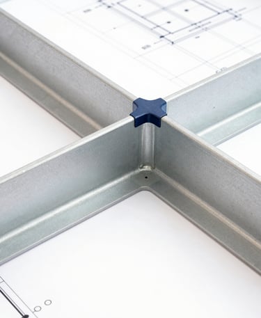 Extreme close-up of a structural joint connecting steel beams, architectural blueprint lines visible in background, bright white studio lighting, sharp focus.