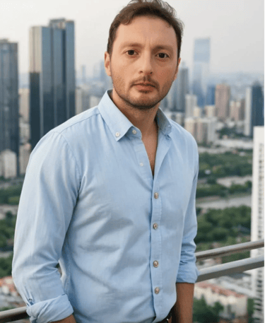 a man in a blue shirt and jeans standing in front of a cityscape
