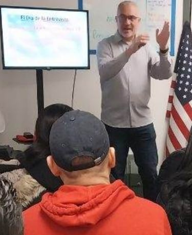 a man in a red jacket is giving a presentation