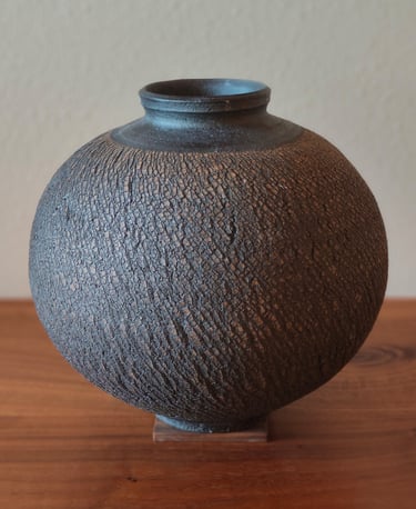 wheel-thrown moon jar with sodium silicate texture, coated with black underglaze and high fired