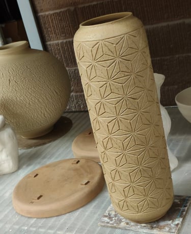 wheel-thrown cylindrical vase with asanoha pattern carving, ready for bisque fire