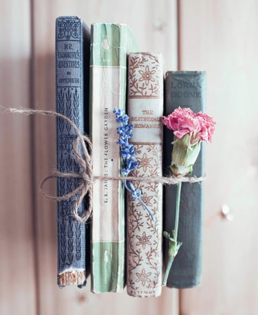 stack of ancient books with flowers - symbolizing learning & growth