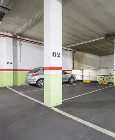 Imagen de un garaje con un  vehículo y bicicleta, con las paredes con franjas verde, rojo y blanco.