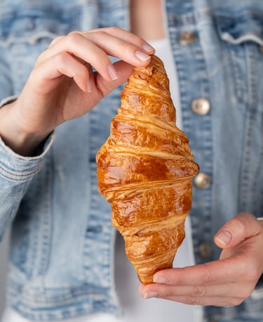 a woman holding a croissant