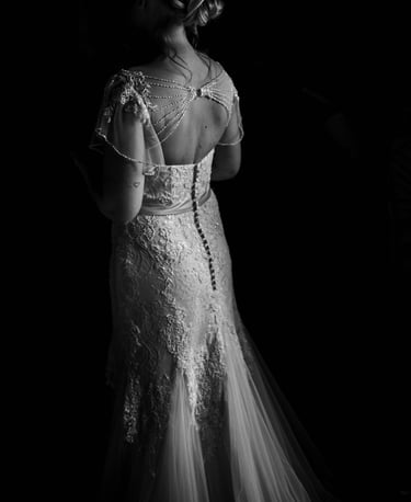 a bride in a wedding dress standing in a black and white photo
