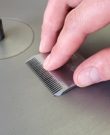Professional clipper blade being sharpened with diamond sharpening equipment