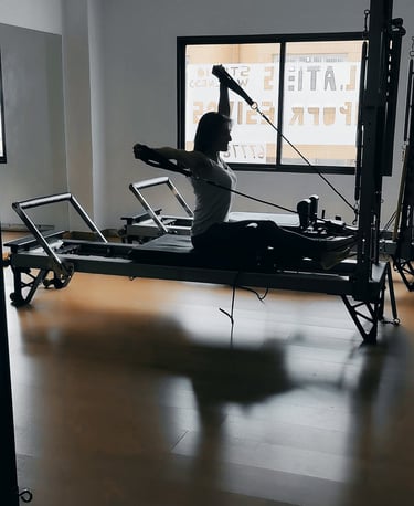 Pilates coach ejecutando un ejercicio de fuerza, utilizando los principios del método Pilates