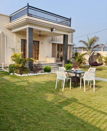 Modern luxury PG featuring a green lawn with a patio set and a second-story balcony.