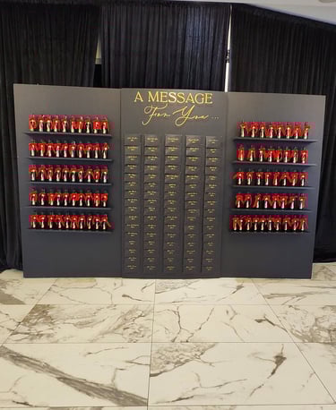 black seating chart with champagne bottle favors with red bow ties