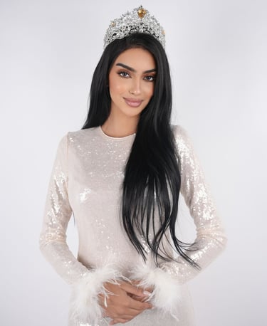Elegant seated pose with a soft backdrop, highlighting a polished and professional look.