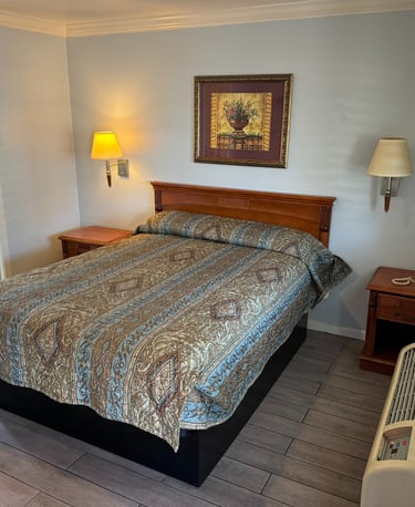 a motel room with a bed and a lamp