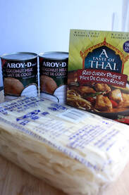 cans of coconut milk, red curry paste and rice noodles all in their packaging