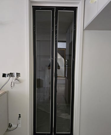Modern black framed glass bifold doors installed in a residential interior renovation.