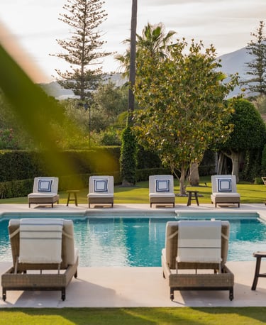 Sunlit pool terrace with lined sunbeds