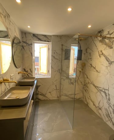 a bathroom with a marbled wall and a glass shower