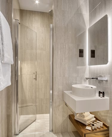 Luxury hotel bathroom – Sleek marble design with premium toiletries and a glass shower.