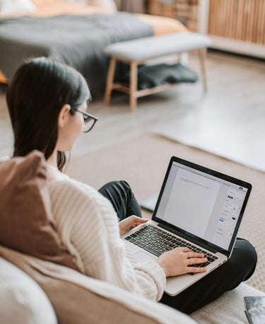 a woman sitting on a couch with a laptop