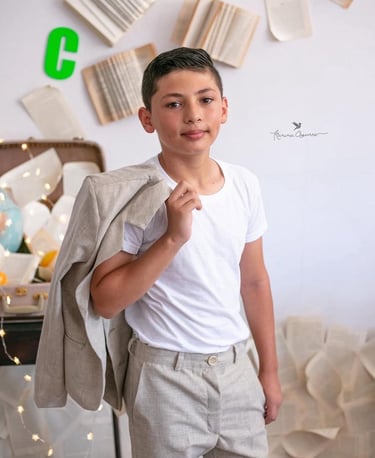 un niños adolescente con un traje de lino beige celebrando su graduación