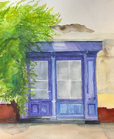 Deep blue wooden door framed by restrained greenery within mineral European façade