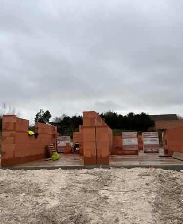 Murs en briques d'argile rouge en cours de construction sur des fondations en béton sur un nouveau c