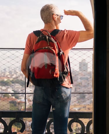 Uomo con zaino guarda il panorama durante un viaggio in autonomia.