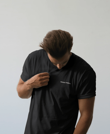 Hombre con camiseta negra con el logo de Sergio Freire en blanco