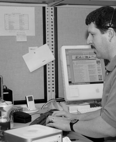 hombre respondiendo mensajes en computadoras viejas