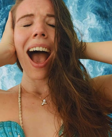 a person dressed up as mermaid, screaming in frustration with an ocean background
