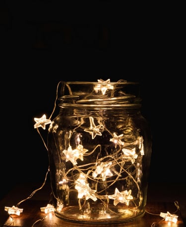 un bocal en verre avec une guirlande d'étoiles électrique à l'intérieur