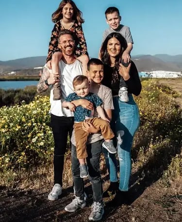 large young caucasian family smiling at sunset by a river in the country
