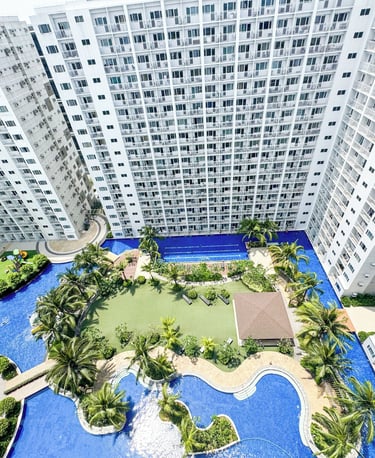 a large apartment complex with a swimming pool and a clock tower