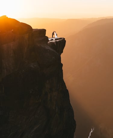 Couple standing on Glacier Point in Yosemite at Golden Hour
