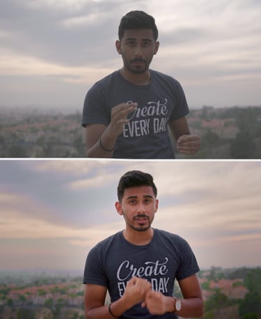 A man wearing a Create Every Day t-shirt stands outdoors during a sunset city view.