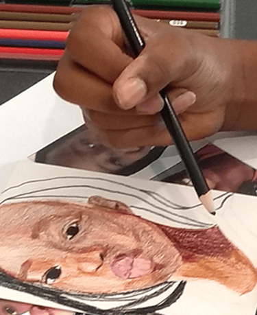 a teen holding a colored pencil and drawing a portrait of a person making a kissy face