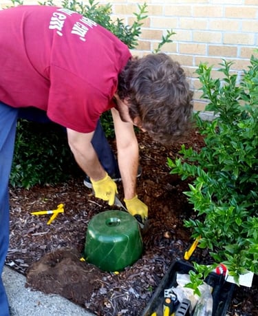 Martin from martins moles, with his tools, setting up mole equipment into a garden of beauty bark