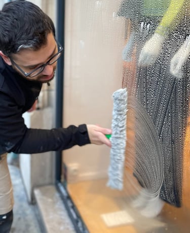 Technicien de M & M Services Pro nettoyant la vitrine du magasin Léo et Ugo à Rouen