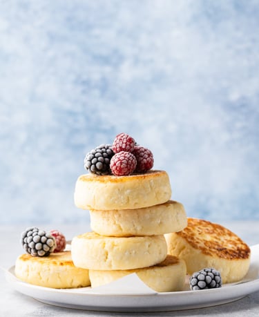 a stack of cottage cheese pancakes with berries on a plate