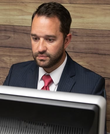 a man in a suit and tie is sitting at a desk