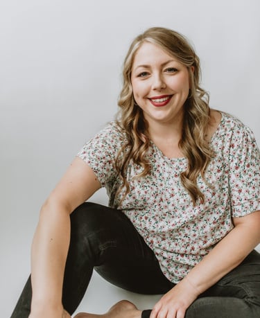a woman sitting on a white surface with a white background