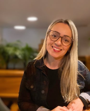 uma mulher de óculos e jaqueta preta sorrindo