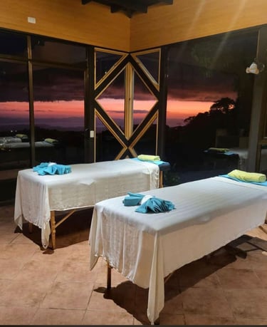 two massage beds in a room with a view of the ocean