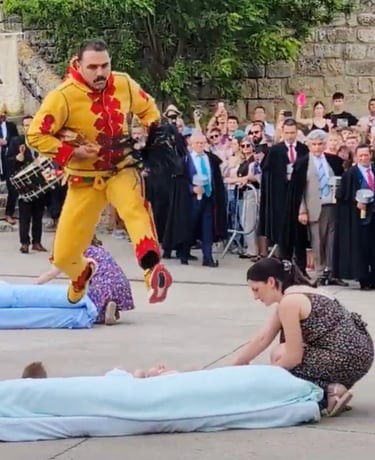 El Colacho salta sobre un bebé en un colchón ante la multitud y la cofradía de negro.