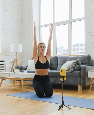 Mujer joven sentada sobre un tapete de yoga en su sala de estar, estirando los br