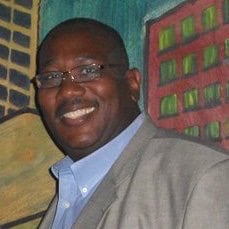 a man in a suit and glasses smiling