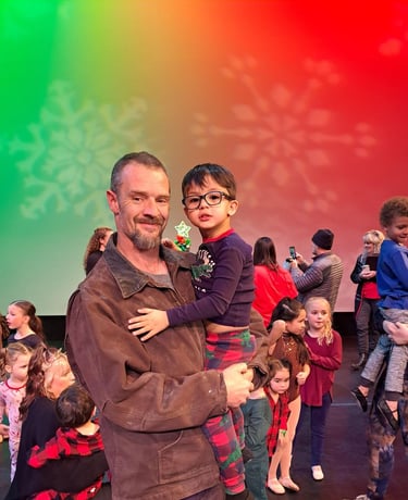 a man and a child are standing in front of a colorful background
