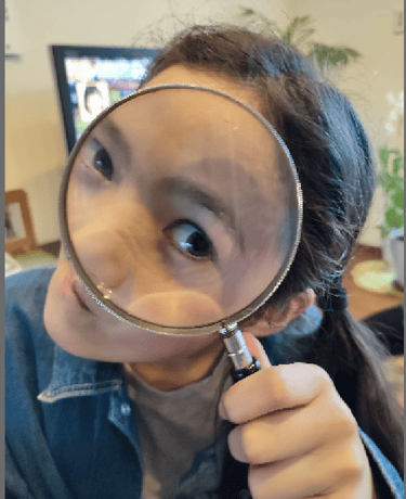 a girl peeping through a magnifying glass